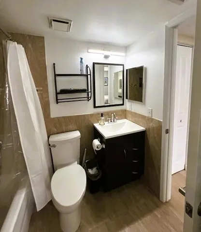 a bathroom with a sink vanity mirror and toilet