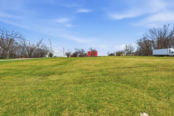 a view of a field with an trees in the background