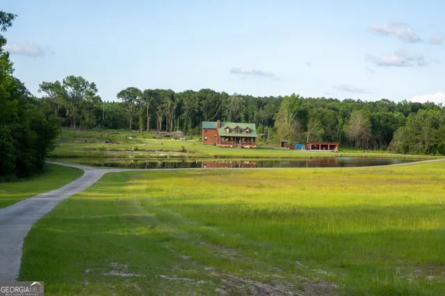 a view of a house next to a lake with a large trees