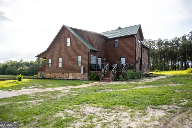 a kitchen with stainless steel appliances granite countertop a refrigerator a stove top oven a sink and a dining table with wooden floor