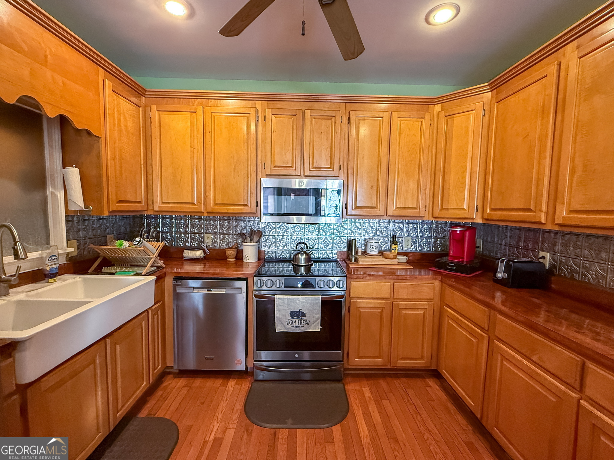 1940 Horne Road Eastman, GA 31023 - Photo 28 of 94 a kitchen with stainless steel appliances granite countertop wooden cabinets a sink dishwasher a stove and a refrigerator with wooden floor