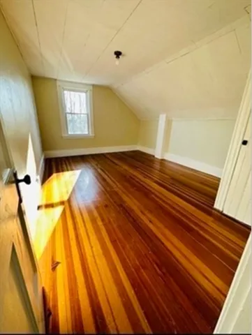 a view of a room with wooden floor and a window