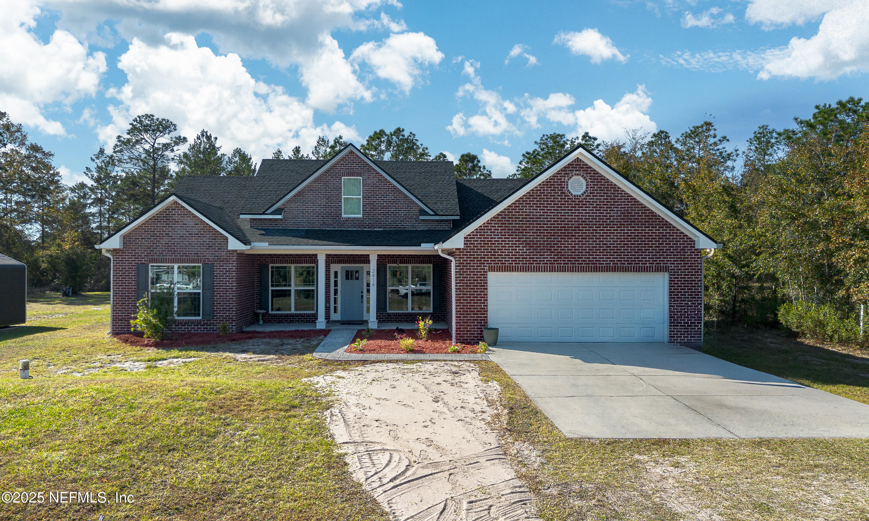 a front view of a house with a yard outdoor seating and garage