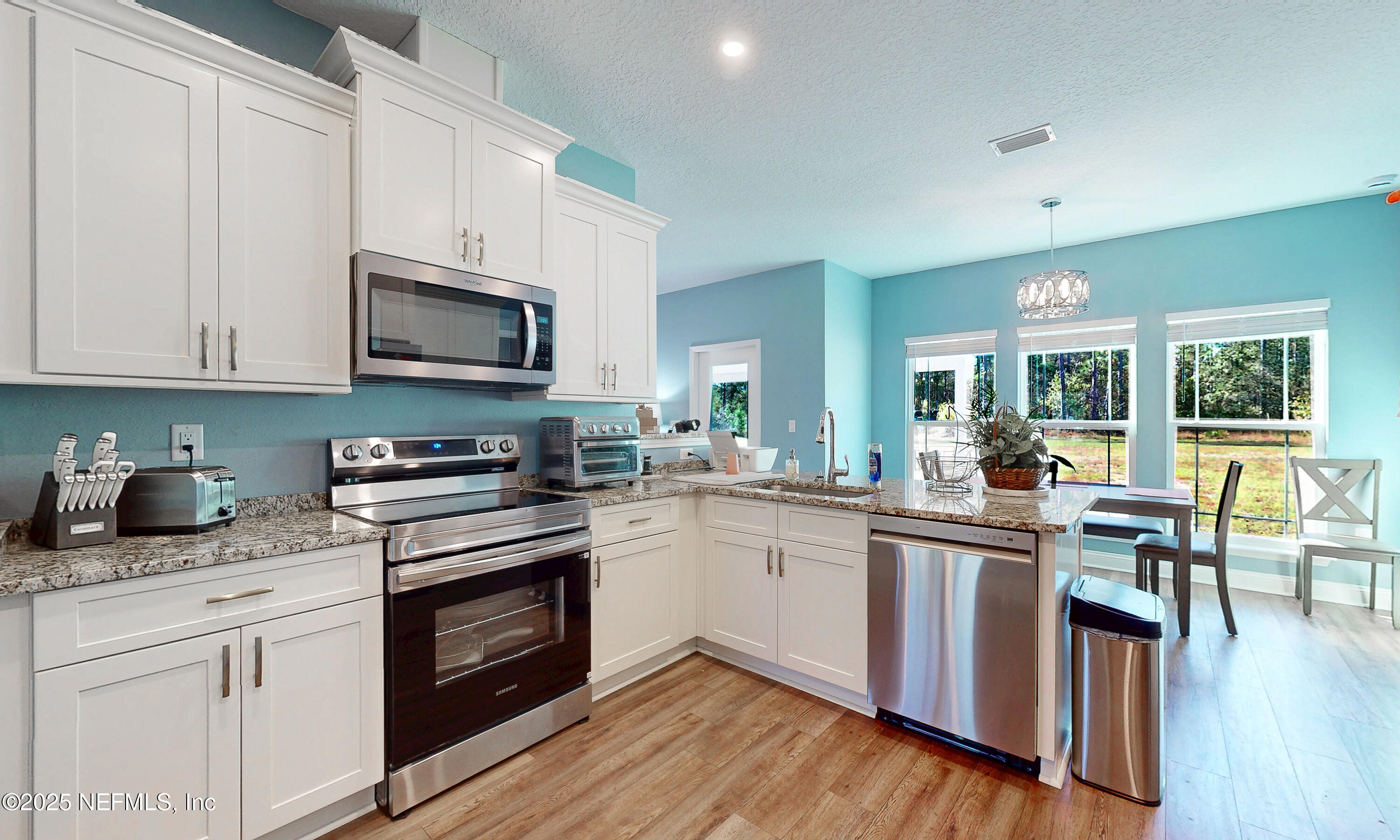 2414 Range Line Road Middleburg, FL 32068 - Photo 15 of 39 a kitchen with granite countertop appliances cabinets and wooden floor