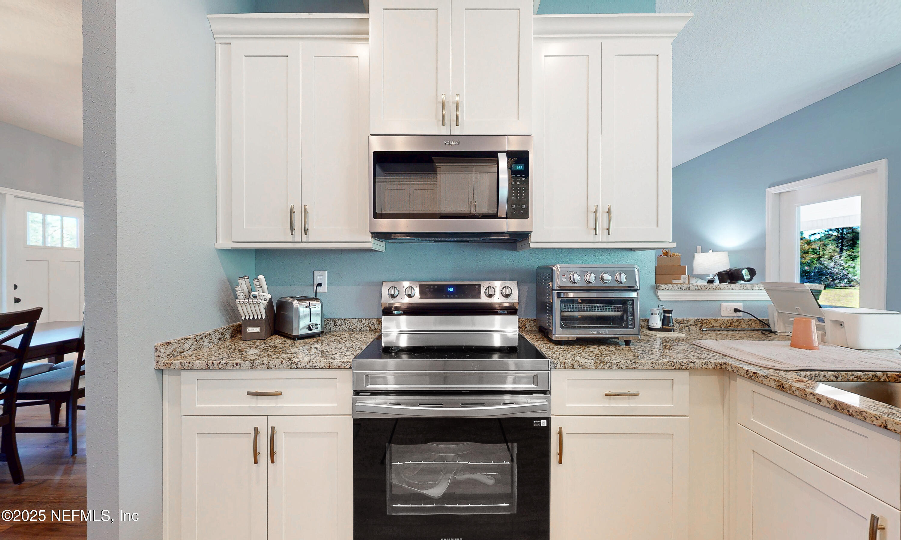 2414 Range Line Road Middleburg, FL 32068 - Photo 16 of 39 a kitchen with granite countertop white cabinets and a stove top oven