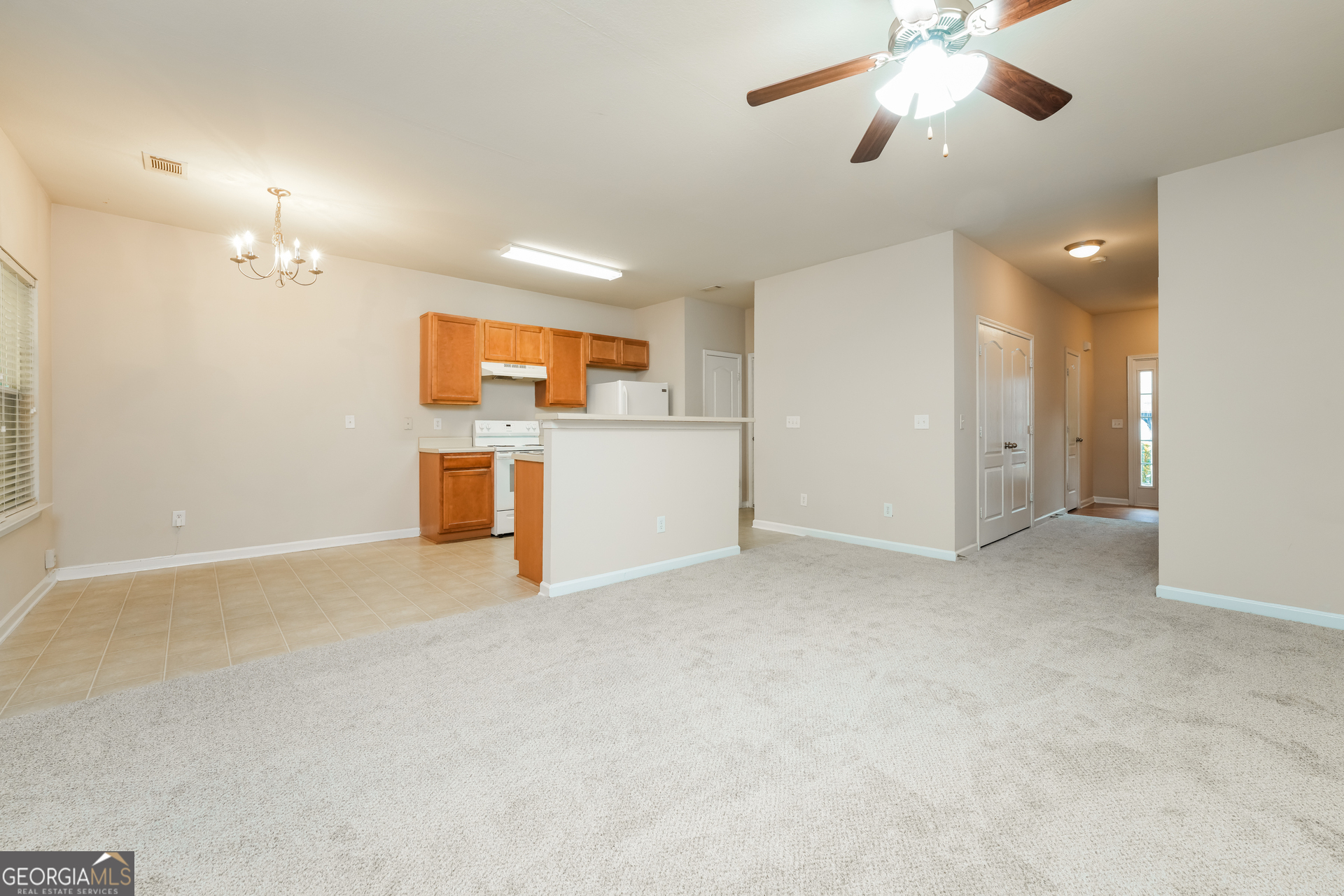 1259 Chinon Point Lithonia, GA 30058 - Photo 3 of 15 an empty room with chandelier fan and windows