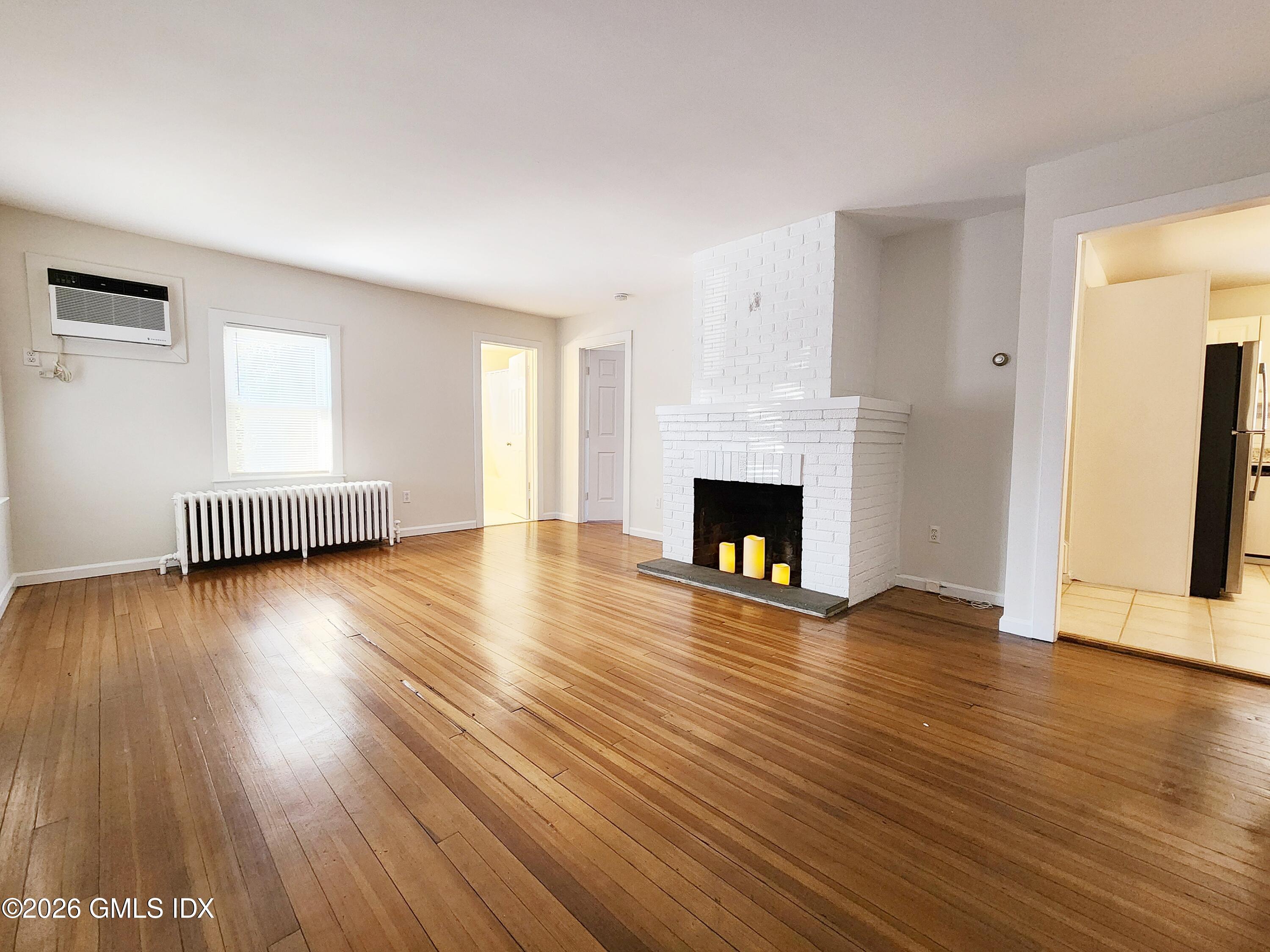 79 Valley Road Cos Cob, CT 06807 - Photo 2 of 20 a view of an empty room with wooden floor and a fireplace