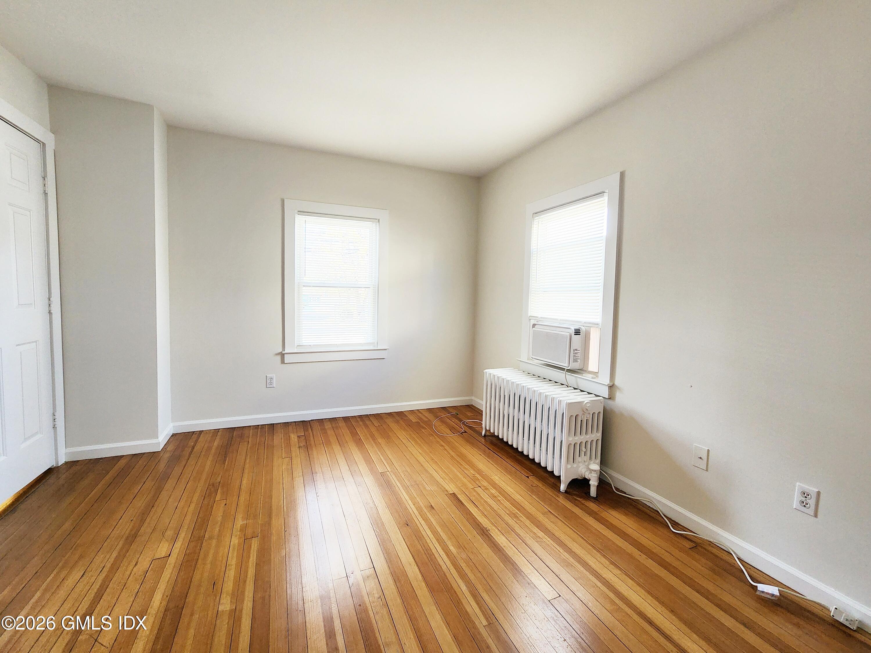 79 Valley Road Cos Cob, CT 06807 - Photo 7 of 20 an empty room with wooden floor and windows
