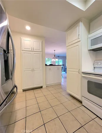 a kitchen with a refrigerator a stove top oven and cabinets
