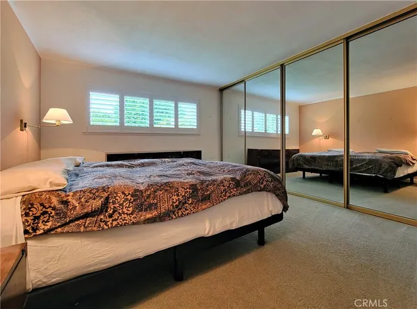 a bedroom with a bed window and a mirror