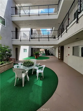 a roof deck with table and chairs and potted plants