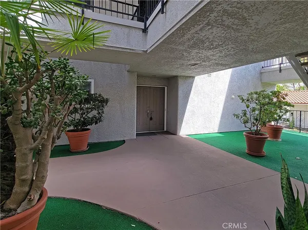 a view of a house with a yard and potted plants