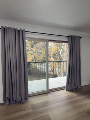 a view of a room with wooden floor and a window