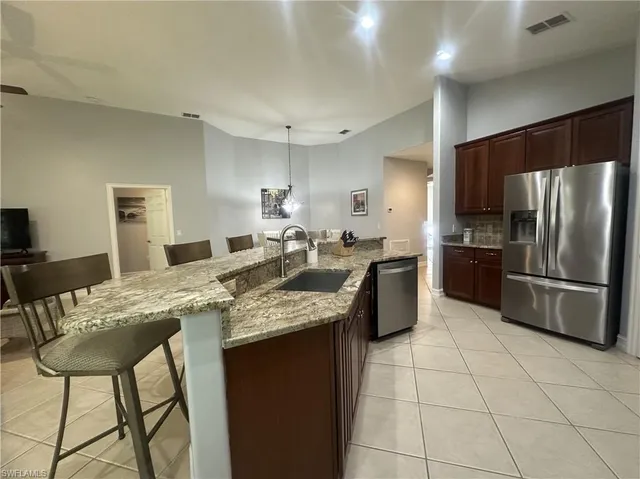 a kitchen with stainless steel appliances granite countertop a stove a sink a refrigerator and a refrigerator