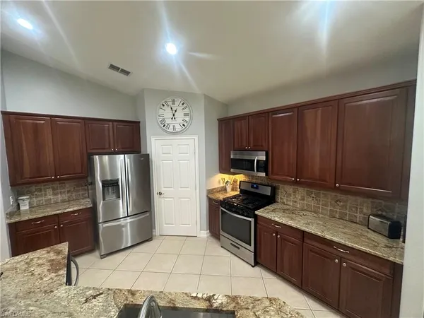 a kitchen with granite countertop stainless steel appliances and wooden cabinets