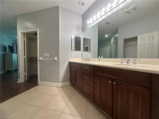 a spacious bathroom with a double vanity sink a mirror and a shower
