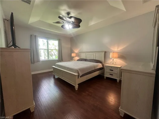 a bedroom with a bed and a flat tv screen on the dresser