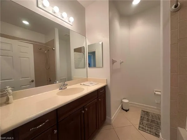 a bedroom with a bed and a flat tv screen on dresser
