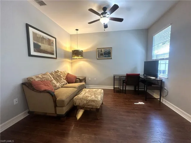 a living room with furniture and a flat screen tv with wooden floor