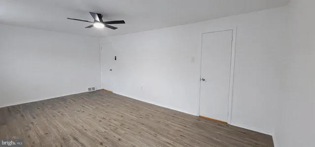 a view of an empty room with wooden floor
