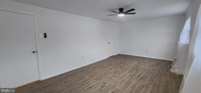 an empty room with fan and windows