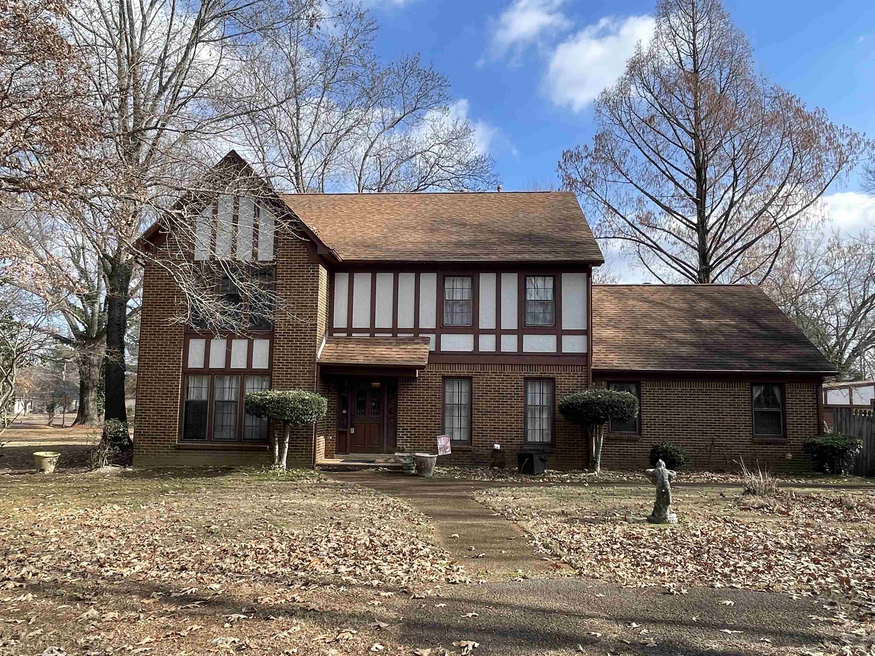 a view of a house with a yard and large tree