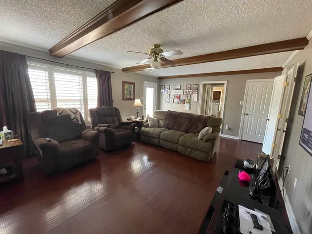 a living room with furniture a flat screen tv and a large window