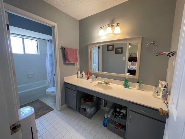 a bathroom with a tub sink and mirror