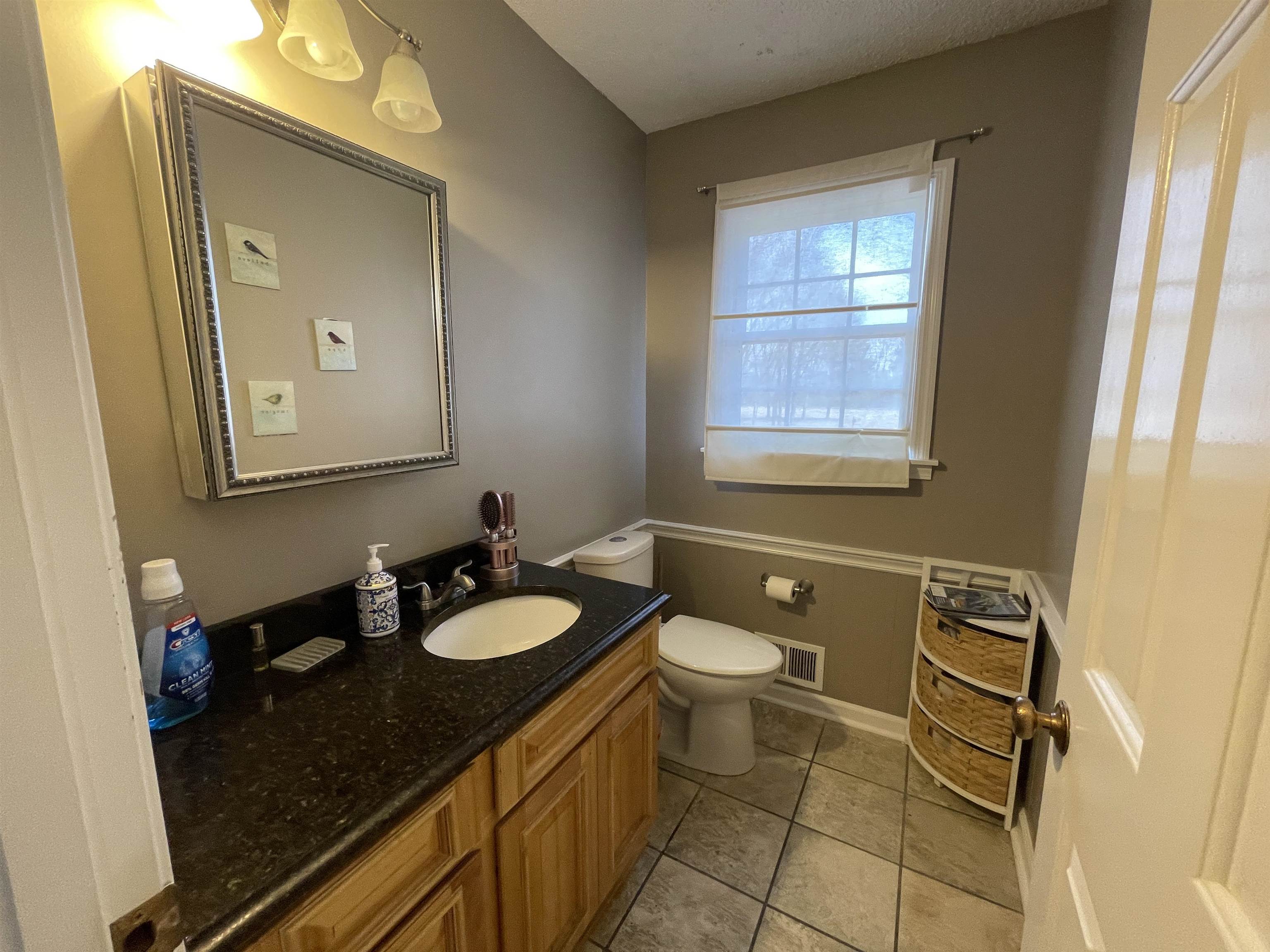 4580 Shadowlawn Road Bartlett, TN 38002 - Photo 28 of 37 a bathroom with a granite countertop sink toilet and mirror