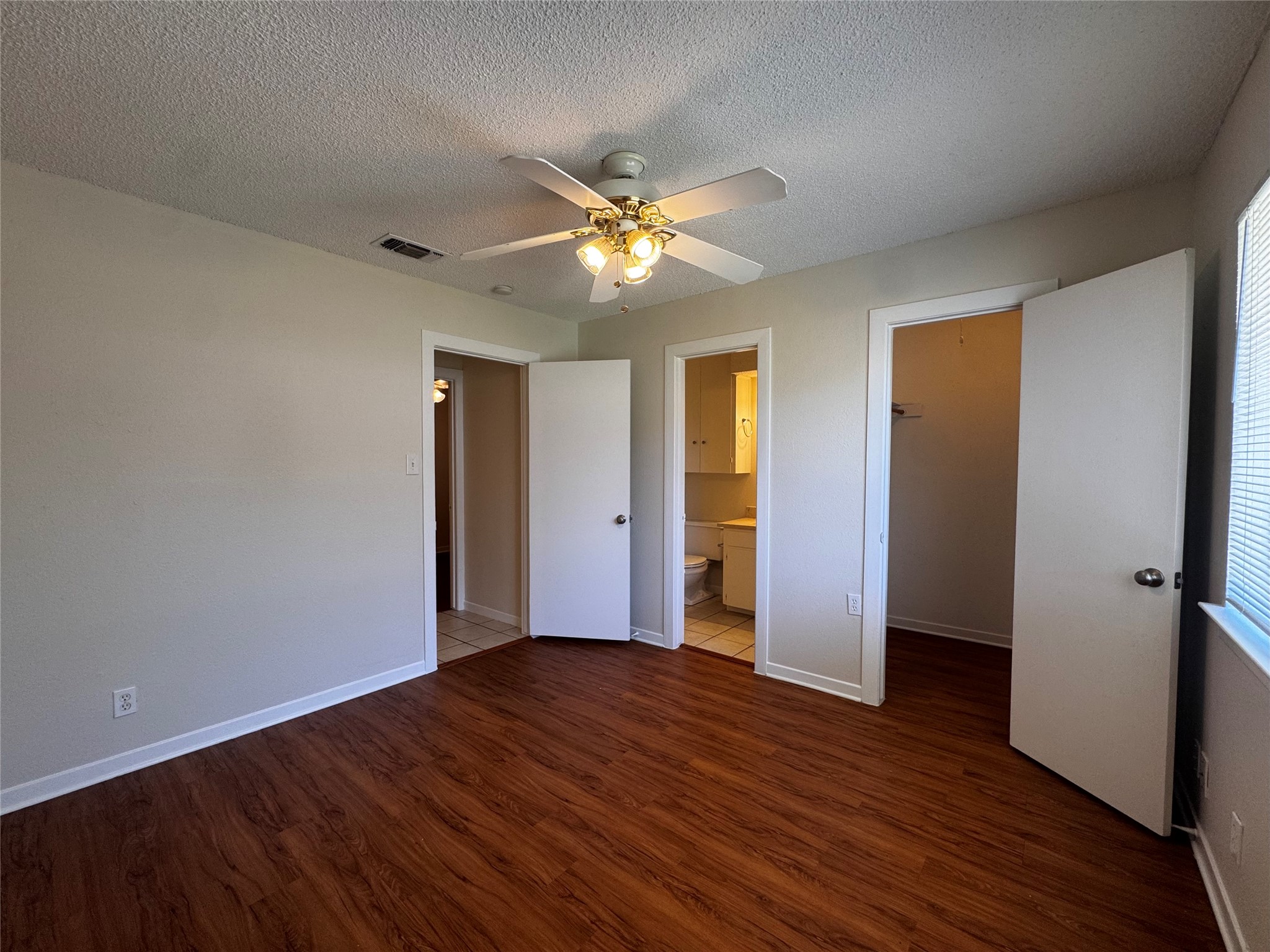 5916 A Cherry Loop Austin, TX 78745 - Photo 9 of 12 Rich wood-toned flooring flows through this comfortable bedroom, offering access to an adjacent bathroom and a walk-in closet.