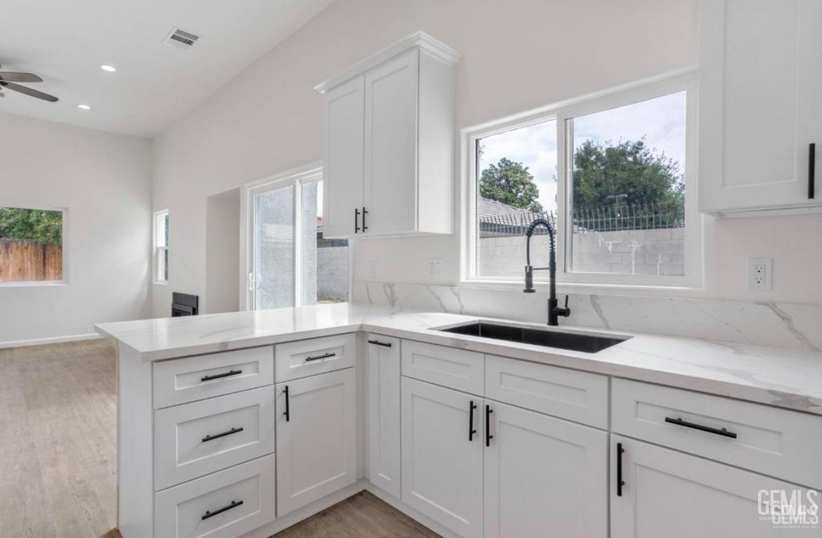 Undisclosed Address Bakersfield, CA 93313 - Photo 5 of 11 a kitchen with white cabinets and a large window