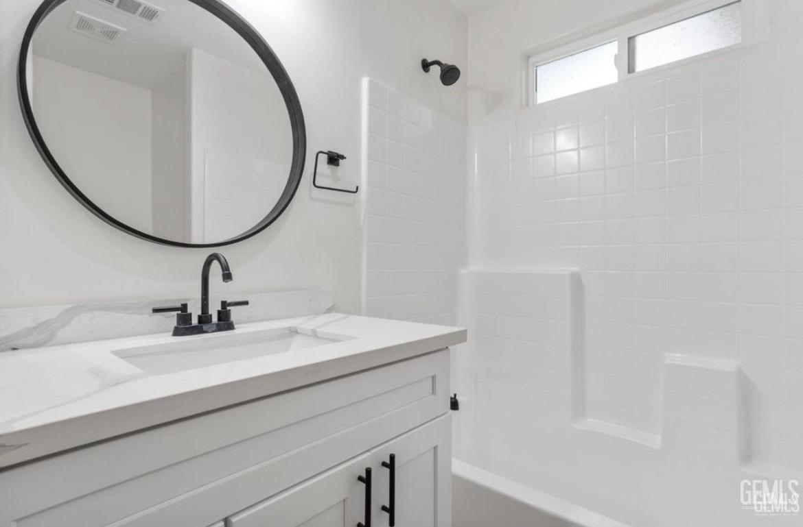 Undisclosed Address Bakersfield, CA 93313 - Photo 7 of 11 a bathroom with a sink a shower and a mirror