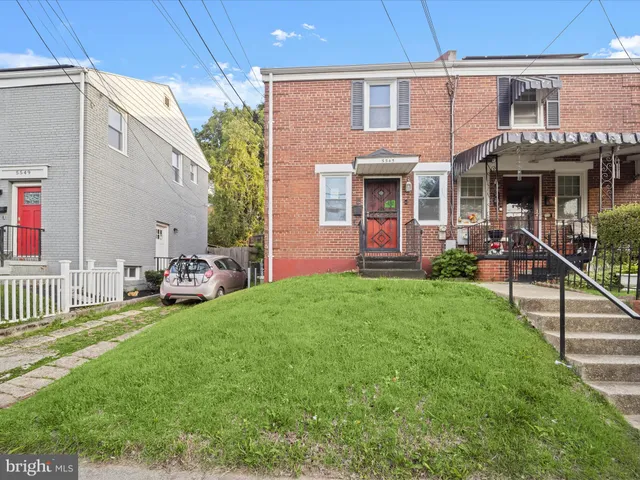 a view of a house with a yard and sitting area