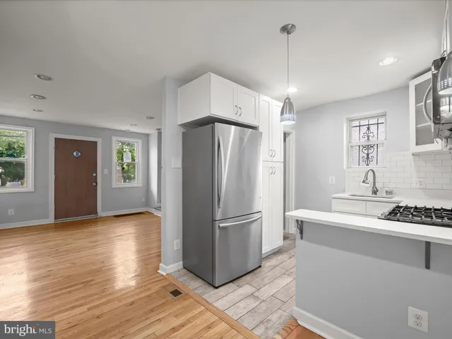 a kitchen with stainless steel appliances granite countertop a refrigerator and a stove top oven