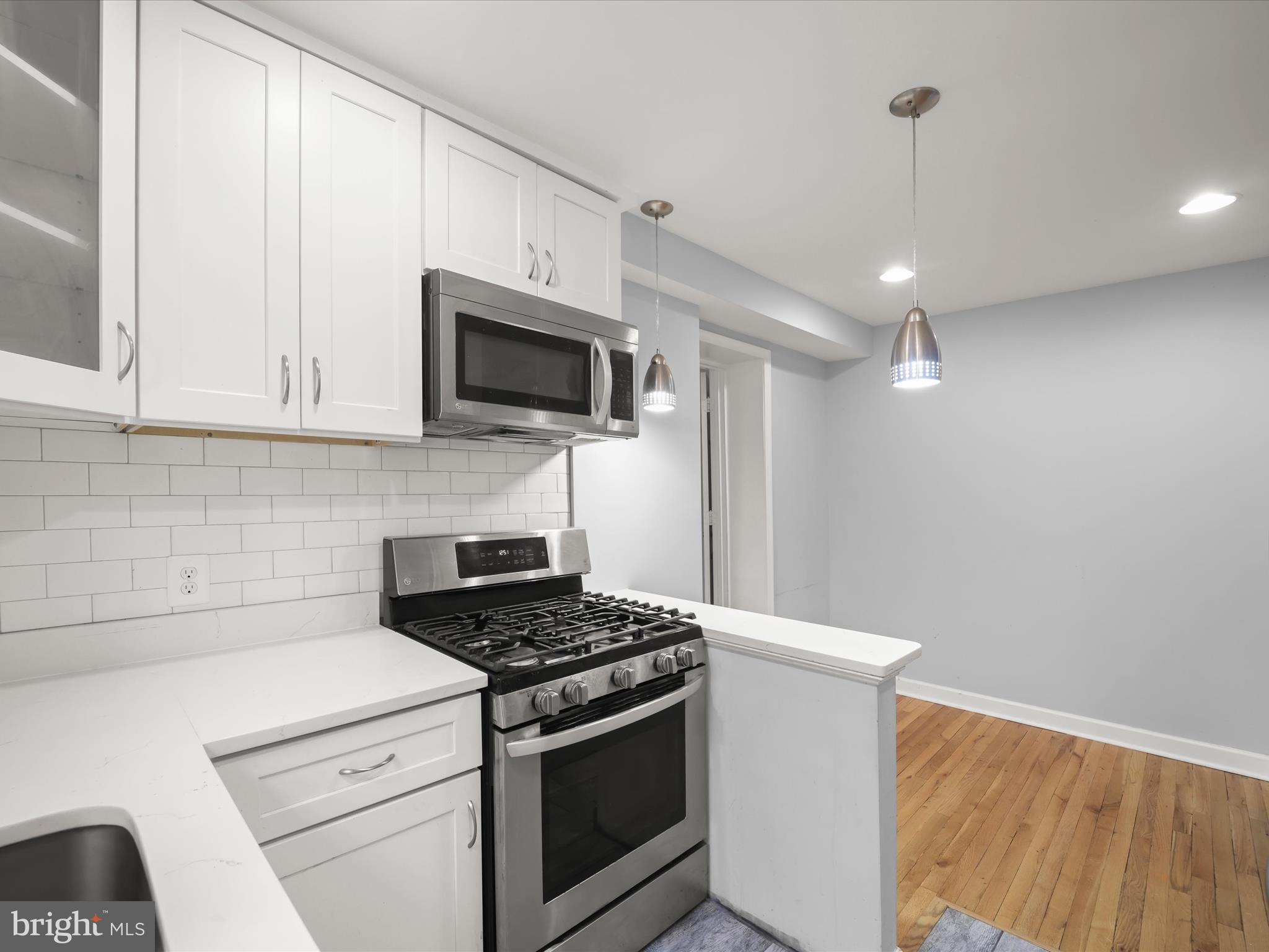 5545 Bass Place Southeast Washington, DC 20019 - Photo 6 of 35 a kitchen with stainless steel appliances granite countertop white cabinets a sink a stove and a refrigerator