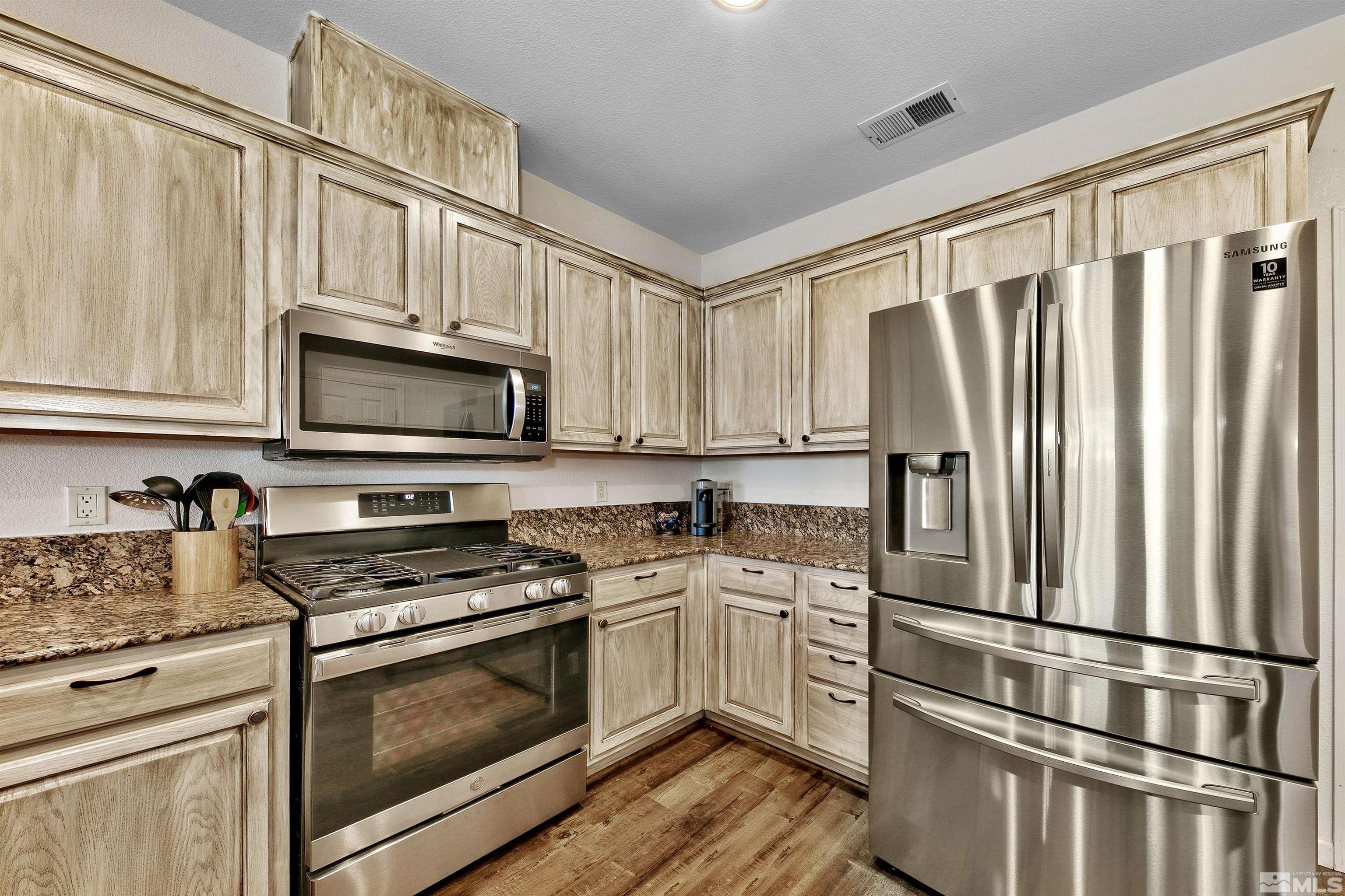 1875 Resistol Drive Reno, NV 89521 - Photo 11 of 25 a kitchen with granite countertop white cabinets and stainless steel appliances