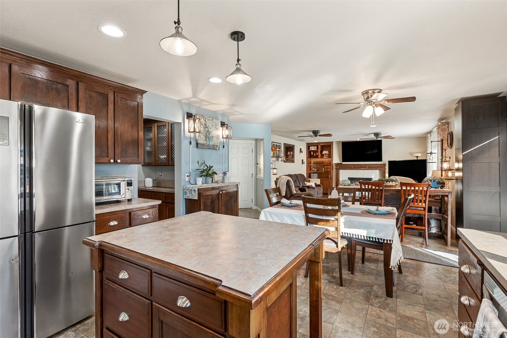 7074 Inlay Street Southeast Lacey, WA 98513 - Photo 6 of 28 a kitchen with stainless steel appliances kitchen island granite countertop a refrigerator a stove a sink a dining table and chairs with wooden floor
