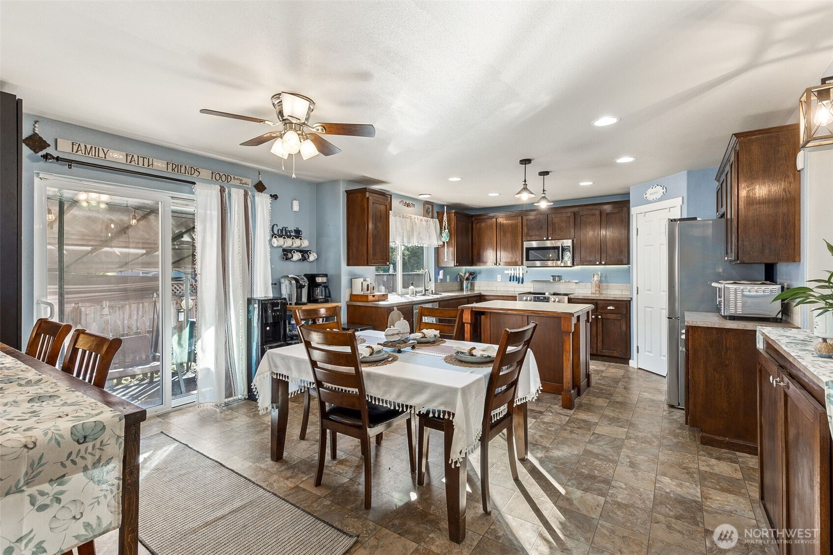 7074 Inlay Street Southeast Lacey, WA 98513 - Photo 8 of 28 a kitchen with stainless steel appliances kitchen island granite countertop a sink a stove a dining table and chairs
