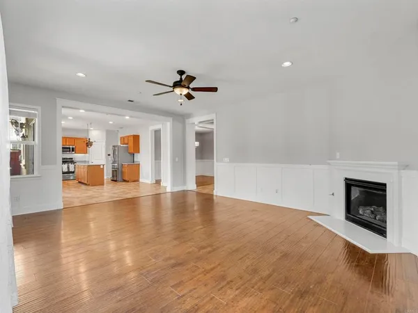 an empty room with windows fireplace and wooden floor