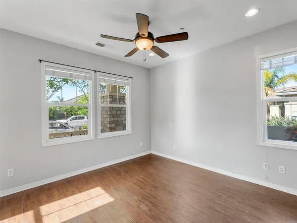 an empty room with cabinet and windows