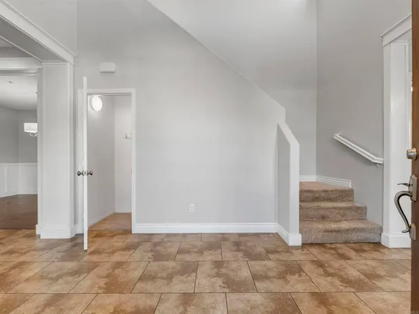 a view of an empty room with window and bathroom