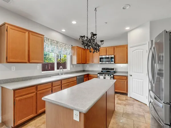 a kitchen with stainless steel appliances granite countertop a sink a stove and a wooden floors