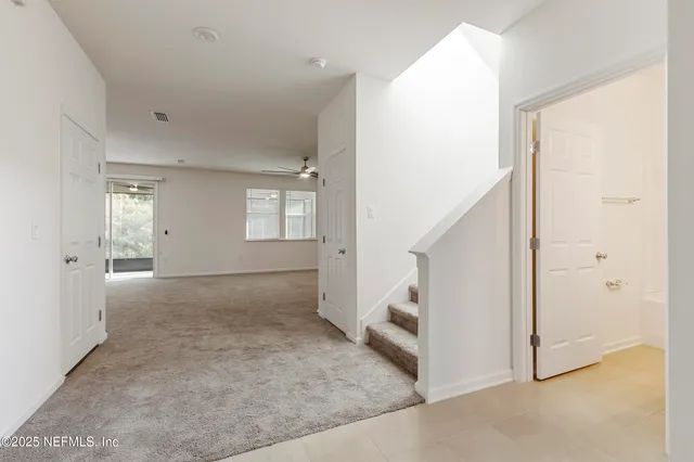 a view of a livingroom with furniture a ceiling fan and window