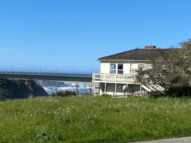 a view of a house with a big yard and large trees