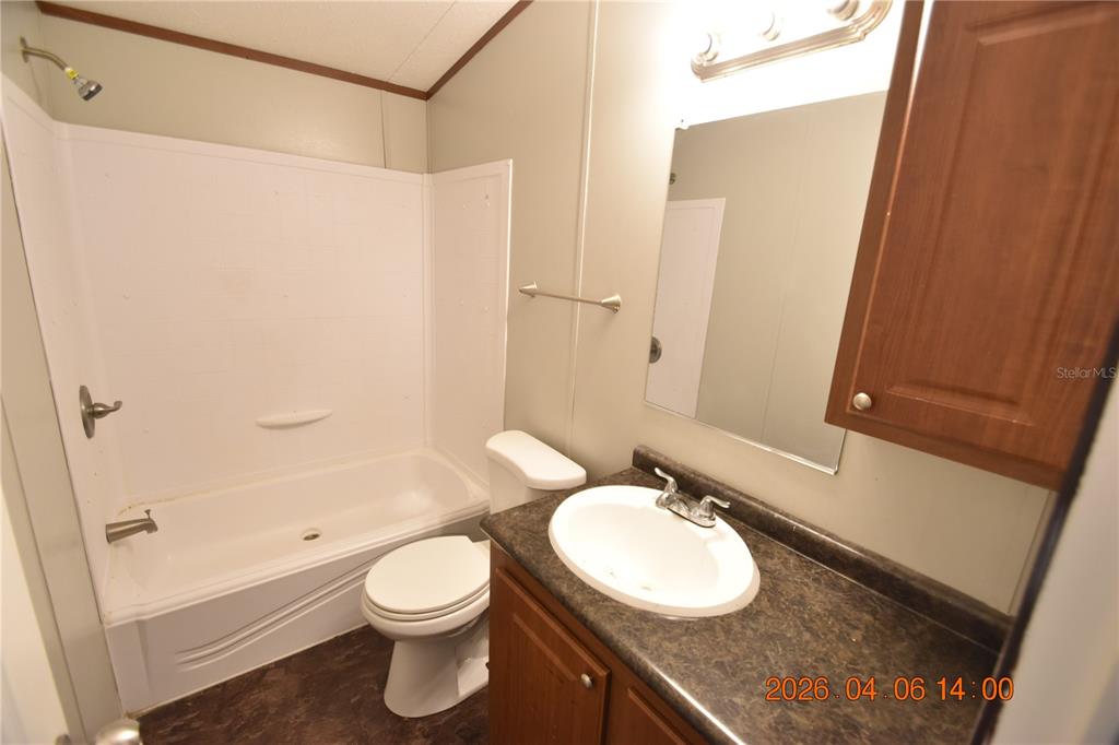 7515 Symmes Road, Unit LOT #5 Gibsonton, FL 33534 - Photo 14 of 23 a bathroom with a granite countertop sink toilet and shower