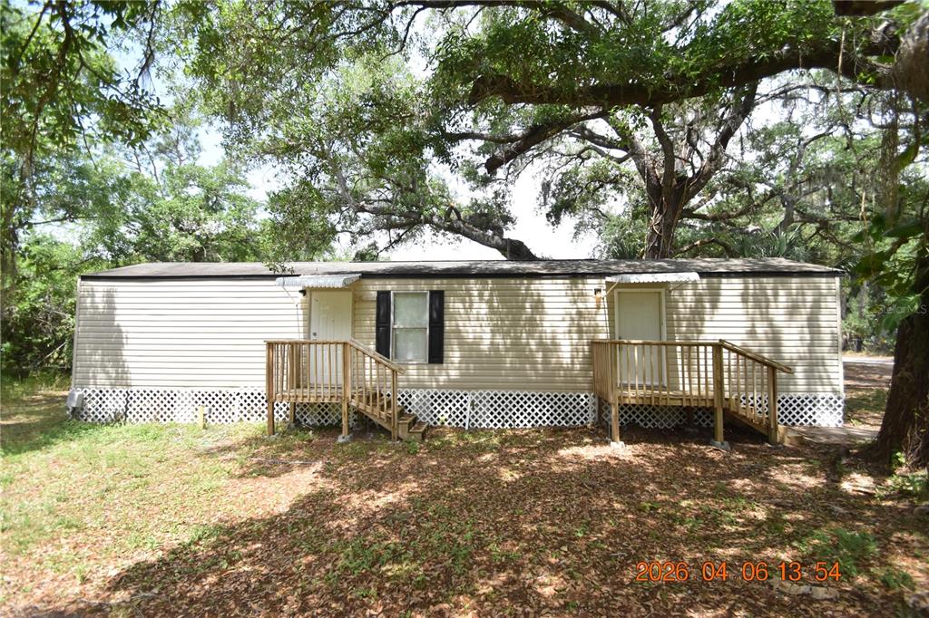 7515 Symmes Road, Unit LOT #5 Gibsonton, FL 33534 - Photo 21 of 23 a front view of a house with a garden