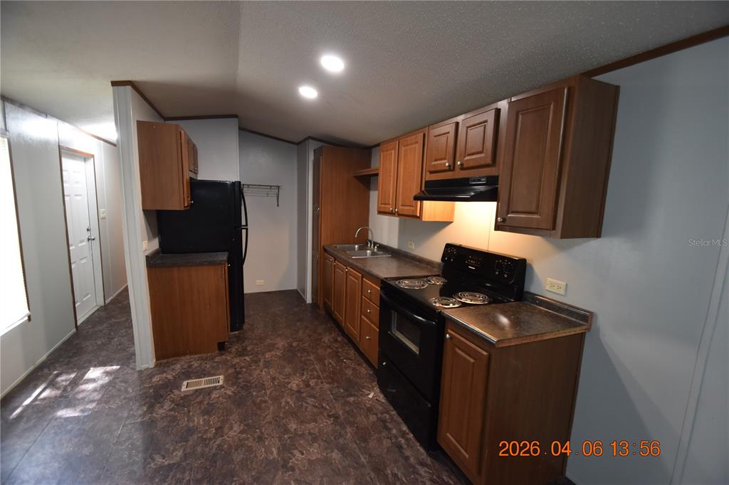 7515 Symmes Road, Unit LOT #5 Gibsonton, FL 33534 - Photo 6 of 23 a kitchen with stainless steel appliances granite countertop a refrigerator stove and sink
