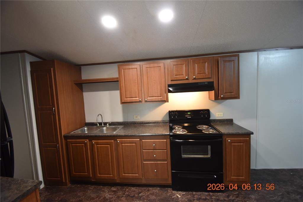 7515 Symmes Road, Unit LOT #5 Gibsonton, FL 33534 - Photo 7 of 23 a kitchen with granite countertop a stove and a refrigerator