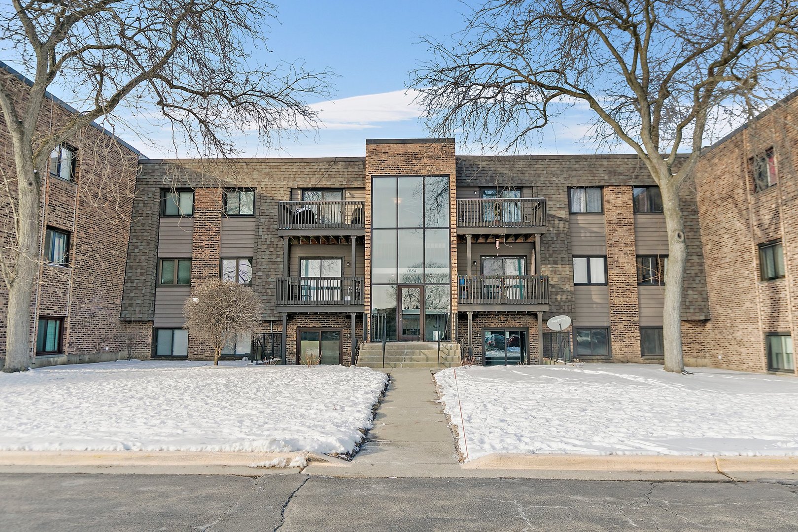 1484 Stonebridge Circle, Unit B4 Wheaton, IL 60189 - Photo 1 of 14 a front view of a residential apartment building with a yard
