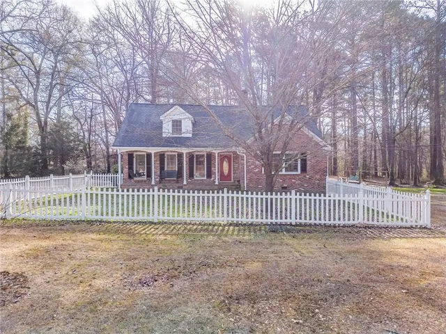 a front view of a house with a yard covered in snow